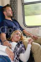 Couple resting with eyes closed in train