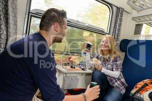 Couple enjoying sandwiches traveling with train