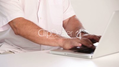 Old man typing on laptop