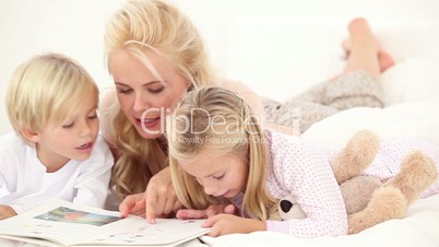 Mother reading book to her children