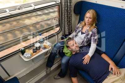 Couple sleeping while traveling with train tired