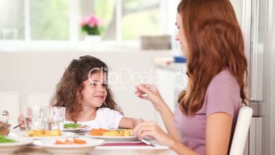 Mother touching hair his daughter a table
