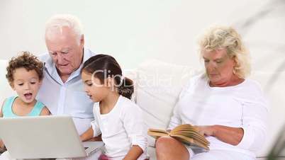Family using a laptop and reading book
