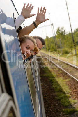 Couple waving with heads out train window