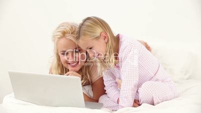 Mother and her daughter using laptop