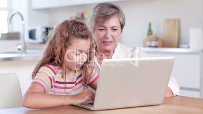 Child using laptop with her grandmother