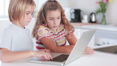 Two children using laptop