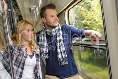 Couple looking out the train window smiling