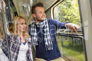 Couple looking out the train window smiling