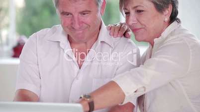 Old man learning to use laptop with partner