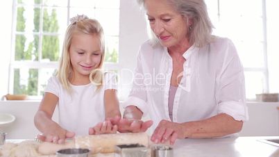 Grandmother and granddaughter using a rolling pin