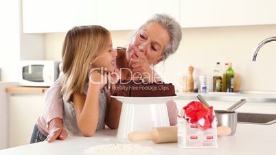 Granny putting icing on granddaughters nose
