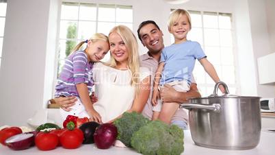 Children in their parents arms in the kitchen