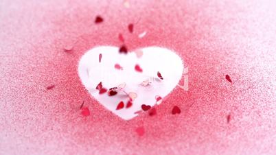 Little pink confetti falling on a heart draw