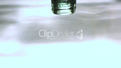 Upside down glass bottle falling in water