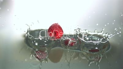 Raspberries falling in water