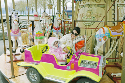 Woman with little child on carousel