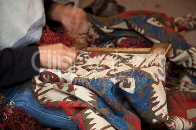 Man  weaving a carpet