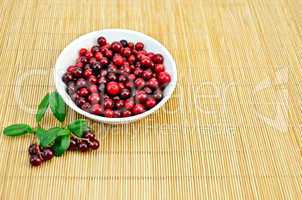 Lingonberry in a cup on a bamboo mat