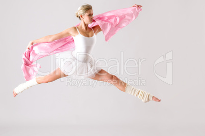 Lovely ballet dancer jumping exercising in studio