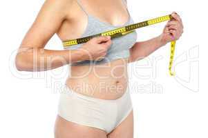 Lingerie clad measuring her breast
