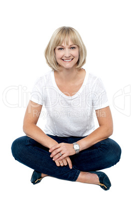 Smiling middle aged woman sitting on the floor