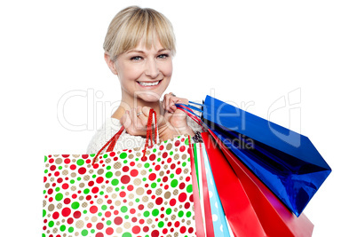 Pretty female carrying shopping bags over shoulders