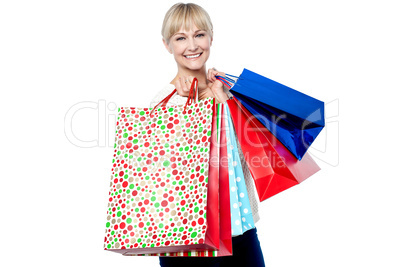 Vivacious woman holding colorful shopping bags