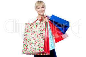 Vivacious woman holding colorful shopping bags