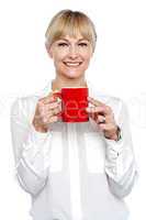 Female manager posing with coffee mug in hand