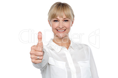 Blonde woman in formal attire showing thumbs up gesture