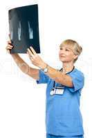 Orthopedic surgeon holding up x-ray to analyze