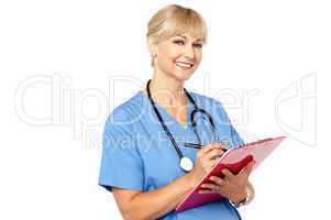 Physician with clipboard smiling at camera