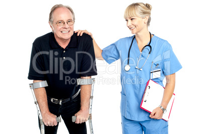Cheerful doctor encouraging her patient to walk with crutches