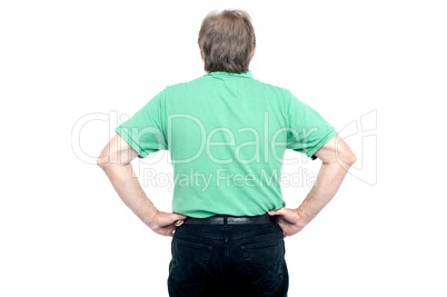 Back pose of elderly guy with hands on his waist