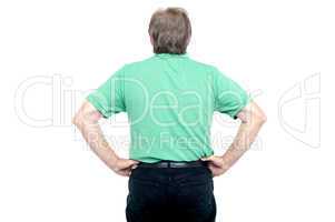 Back pose of elderly guy with hands on his waist