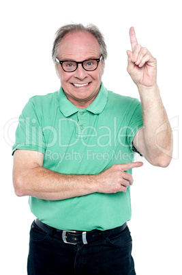 Happy old man pointing upwards