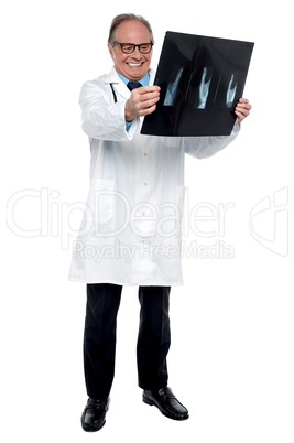Senior medical practitioner reviewing x-ray sheet