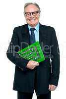 Senior male manager holding big green calculator