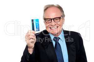 Old man wearing eyeglasses holding up a cash card