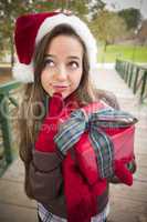 Pretty Woman Wearing a Santa Hat with Wrapped Gift