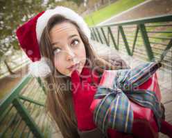 Pretty Woman Wearing a Santa Hat with Wrapped Gift