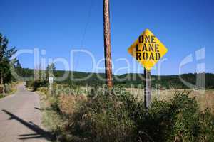 One lane road ahead sign