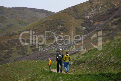 Family of three hiking on trail