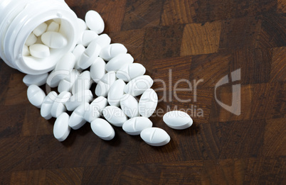 Glass of pills on wood background