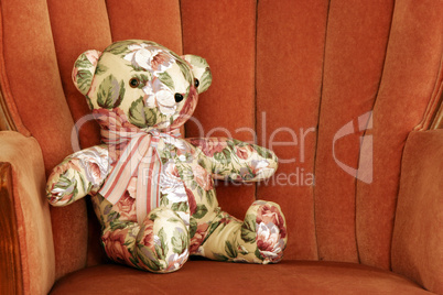 Calico Teddy Bear Sits on Chair