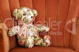 Calico Teddy Bear Sits on Chair