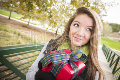 Pretty Woman with Wrapped Gift with Bow Outside