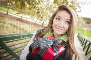 Pretty Woman with Wrapped Gift with Bow Outside