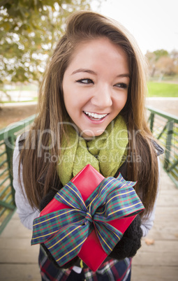 Pretty Woman with Wrapped Gift with Bow Outside